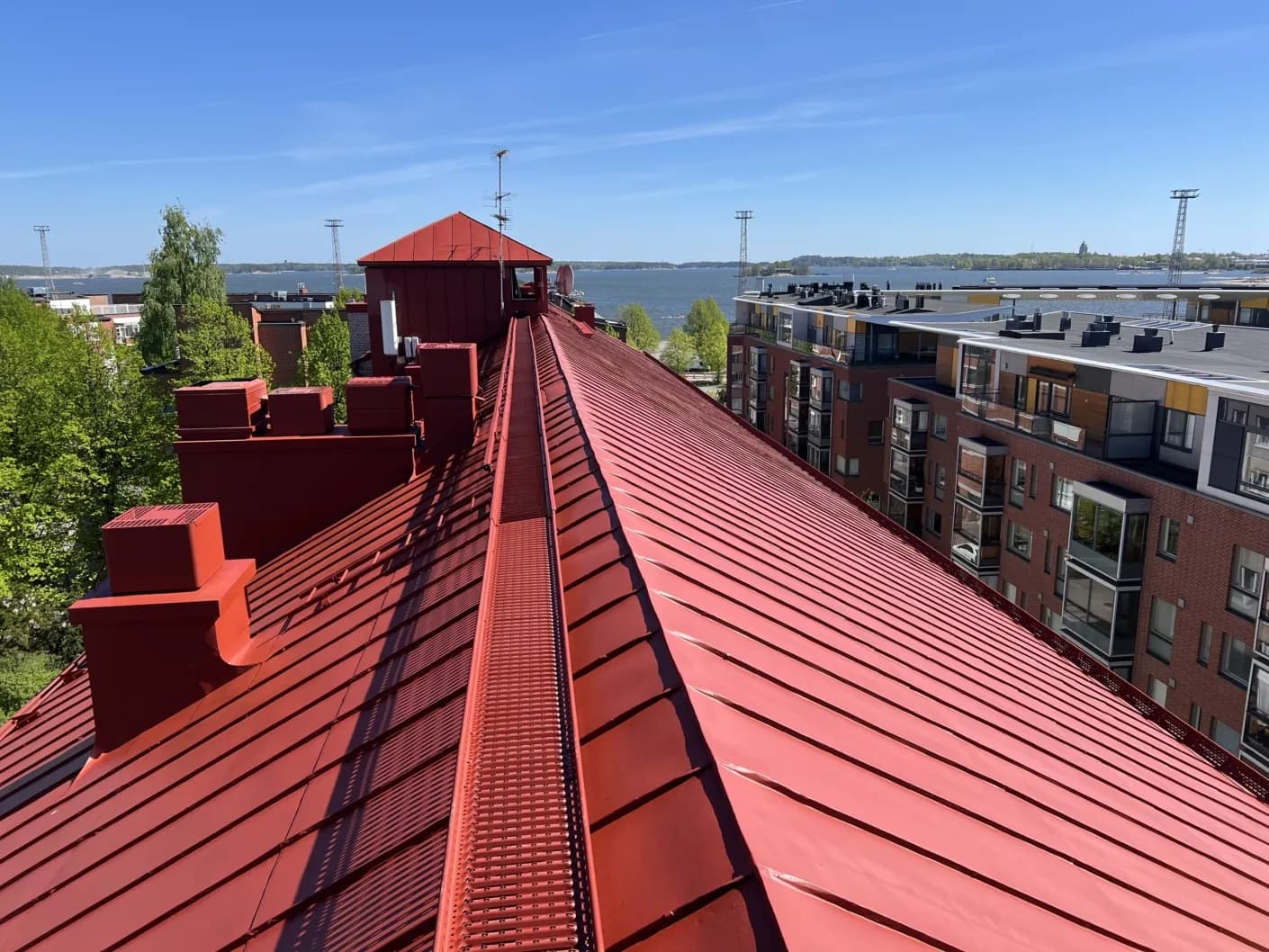 Sama hotellihoone katus pärast värskendust, ühtlane erkpunane pind, sama meri ja linnasiluett taustal