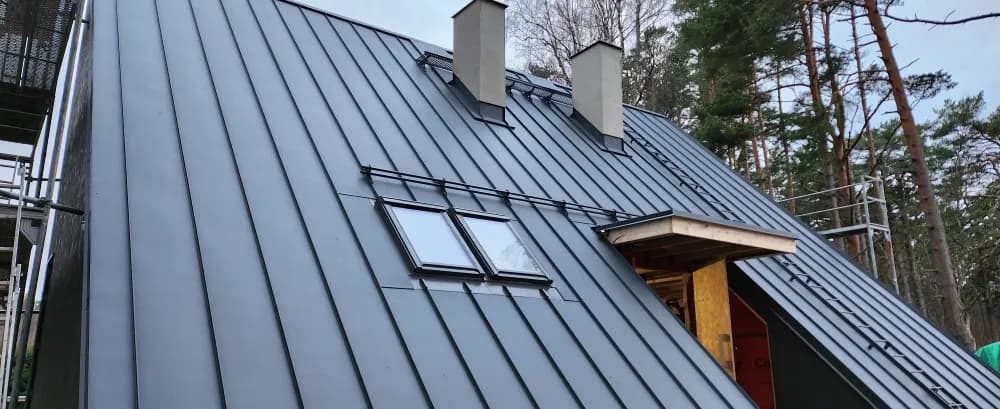 Kaberneeme eramu tumeda valtsplekk-katuse ja kahe korstnaga