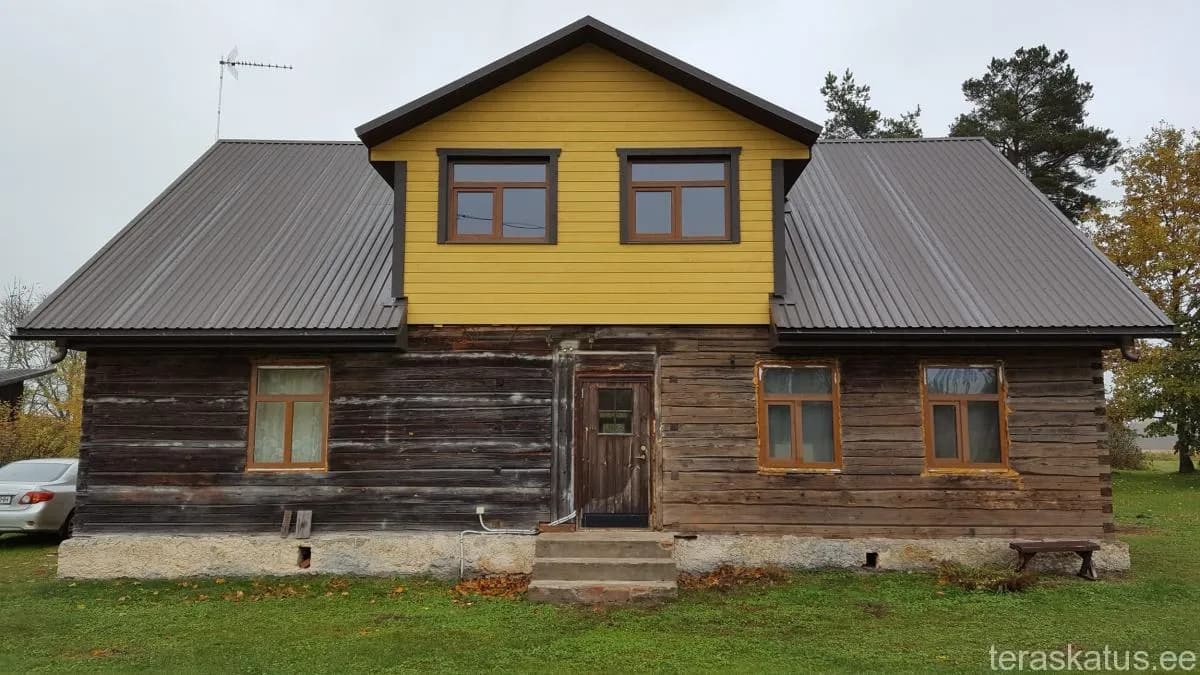 Tumepruun palkhoone uue heleda profiilplekk-katusega ja kollase juurdeehitusega